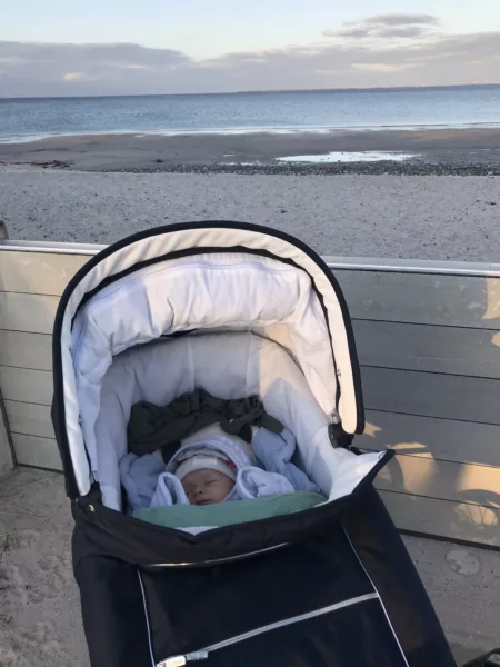 Baby schläft draußen im Kinderwagen